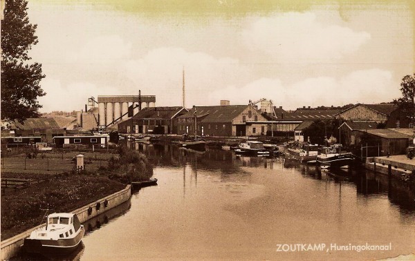 Het Hunsingokanaal met graanhandel Kuhn & Co en de gritfabriek op de achtergrond. Uitgave: CafÃ©-Slijterij 't Anker 1974